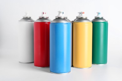 Photo of Cans of spray paint on white background