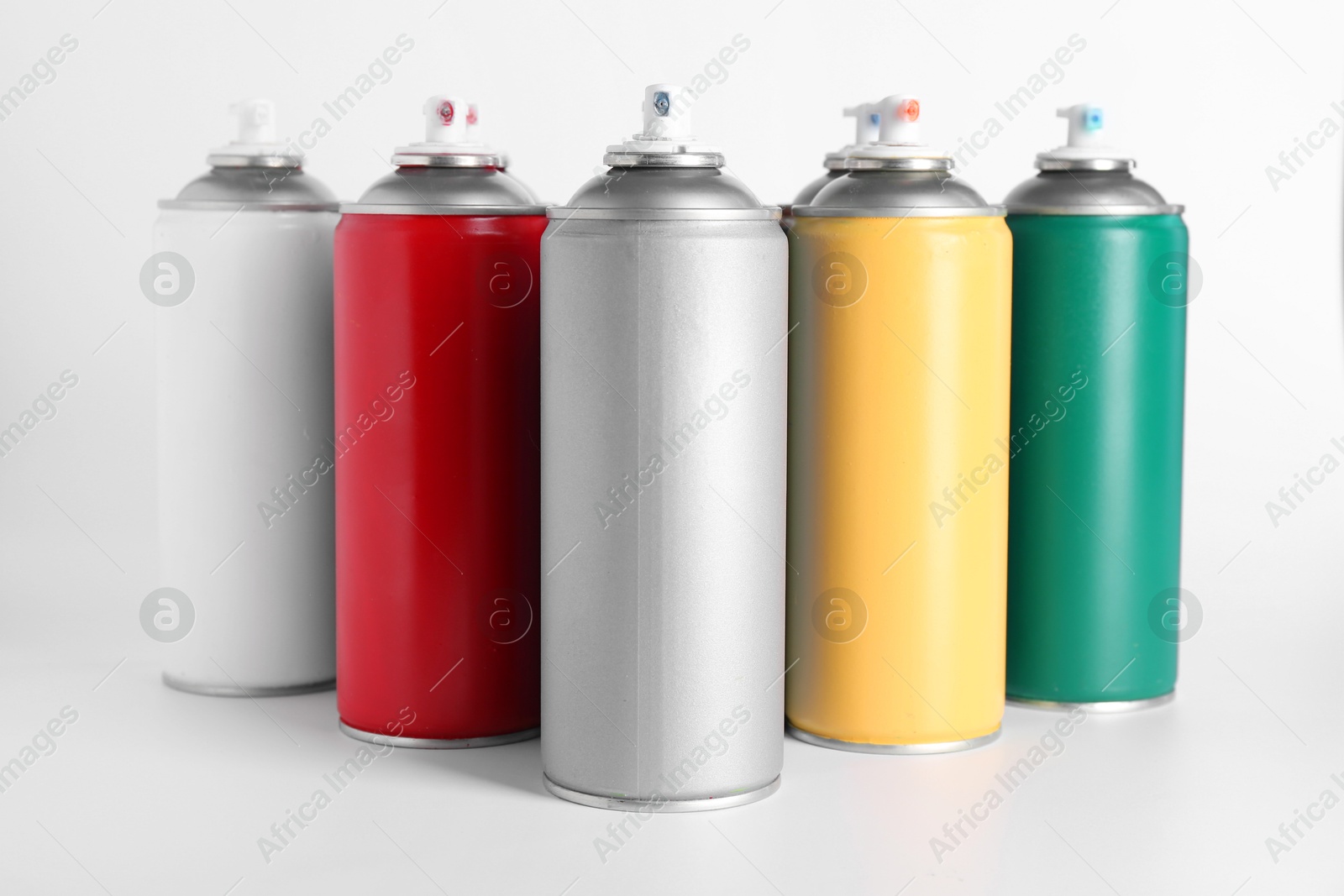 Photo of Cans of spray paint on white background