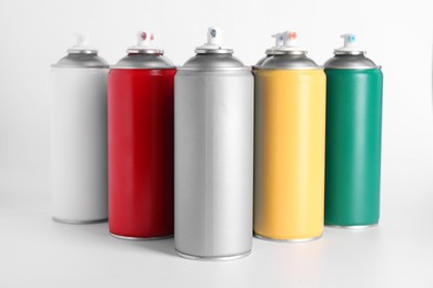 Photo of Cans of spray paint on white background