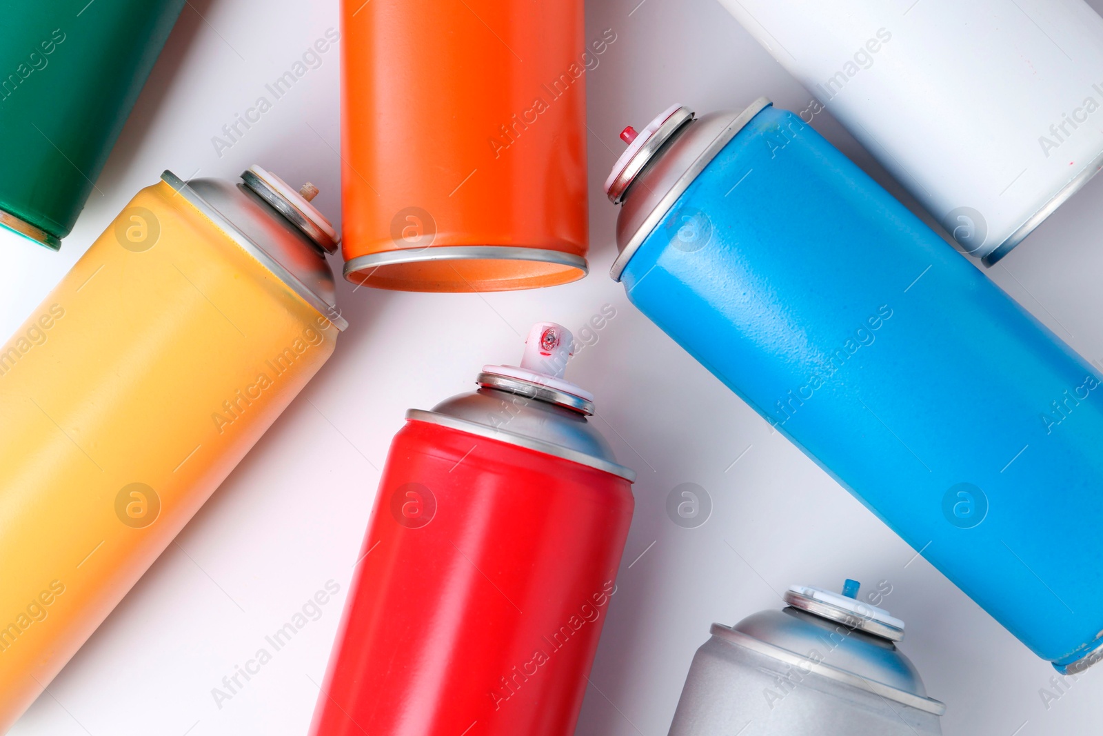 Photo of Cans of spray paint on white background, flat lay