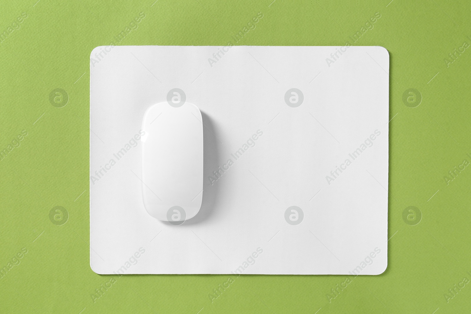 Photo of Wireless mouse and mousepad on green background, top view