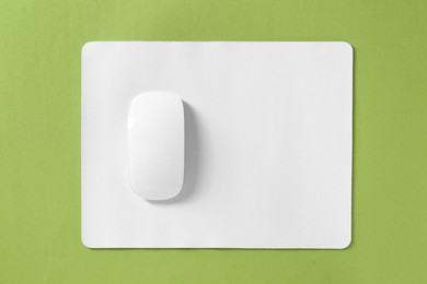 Wireless mouse and mousepad on green background, top view