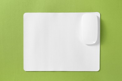 Photo of Wireless mouse and mousepad on green background, top view