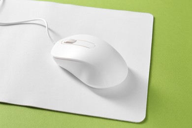 Wired mouse and mousepad on green background