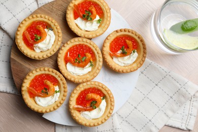 Photo of Delicious canapes with shrimps, red caviar and cream cheese served on light table, flat lay