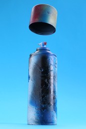 Photo of Spray paint can with cap on light blue background