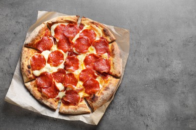 Photo of Tasty pepperoni pizza on grey table, top view. Space for text