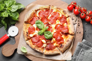 Tasty pepperoni pizza, cutter and ingredients on grey table, top view