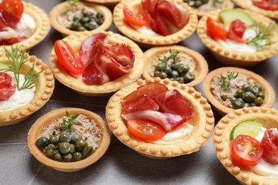 Photo of Different delicious canapes on grey table, closeup