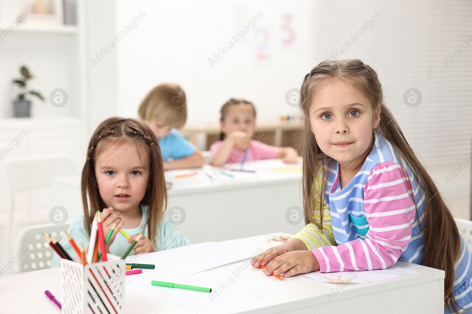 Photo of Group of children drawing at table indoors