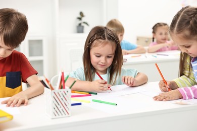 Group of children drawing at table indoors