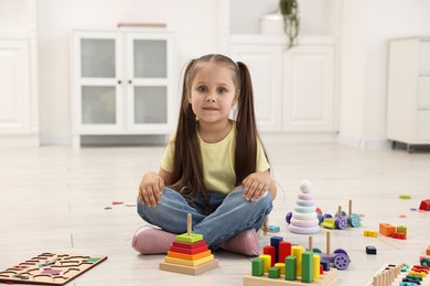 Cute little girl playing on floor indoors