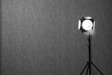 Grey photo background and professional lighting equipment in studio, space for text