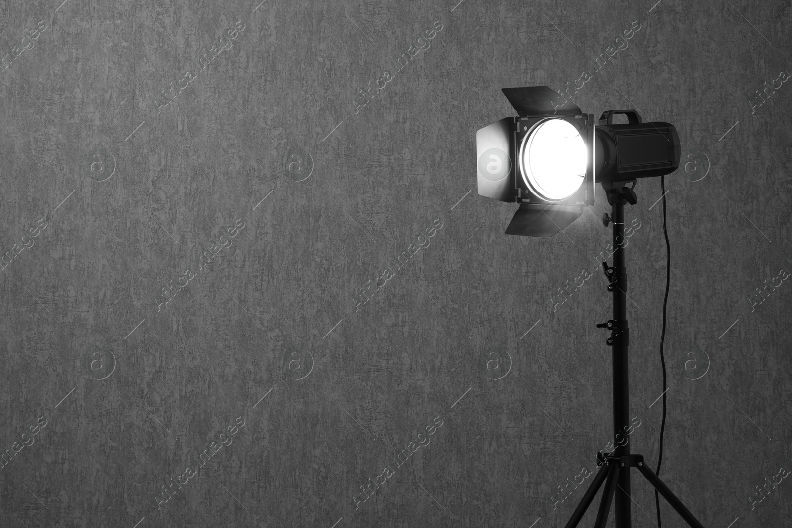 Photo of Grey photo background and professional lighting equipment in studio, space for text