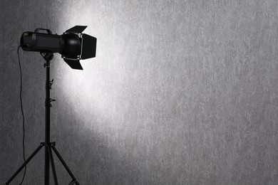 Photo of Grey photo background and professional lighting equipment in studio, space for text