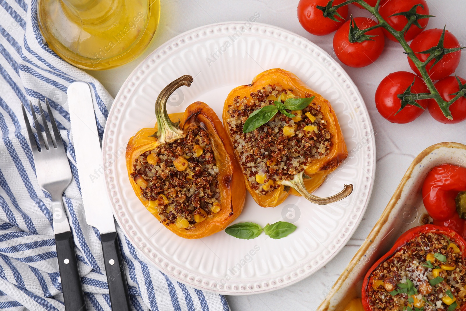 Photo of Quinoa stuffed peppers with corn and basil on white textured table, flat lay