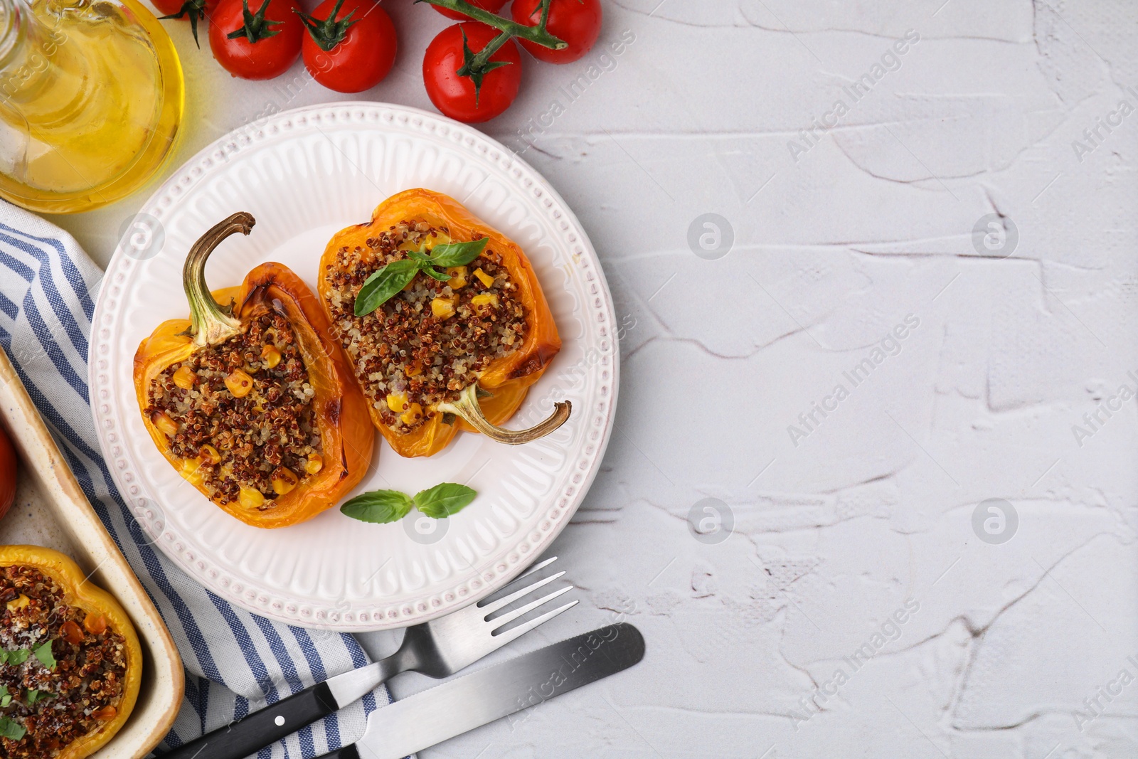 Photo of Quinoa stuffed peppers with corn and basil on white textured table, flat lay. Space for text