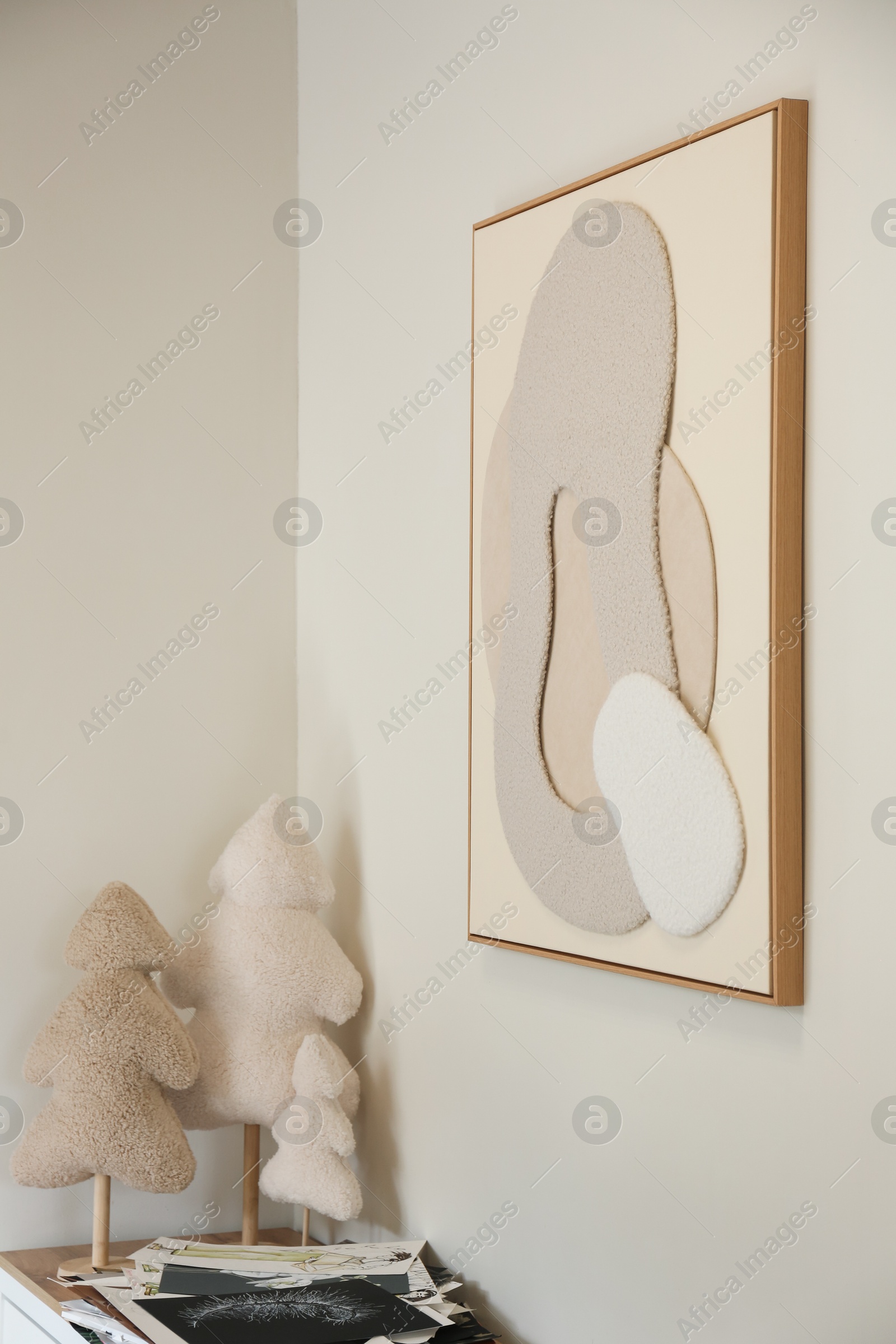 Photo of Frame with abstract artwork on wall and decorative elements in studio