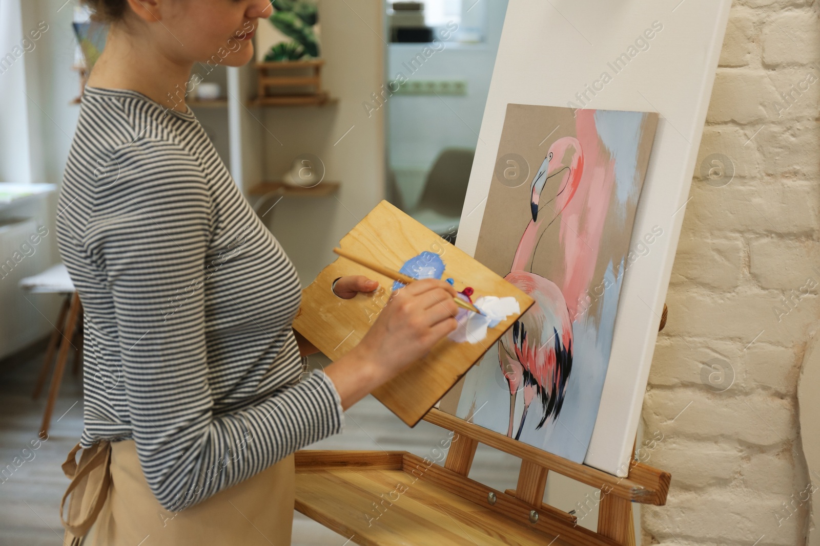 Photo of Woman drawing picture with brush in studio, closeup