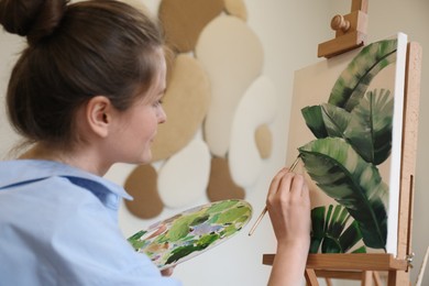 Woman with brush painting tropical leaves in studio