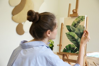 Photo of Woman with brush painting tropical leaves in studio