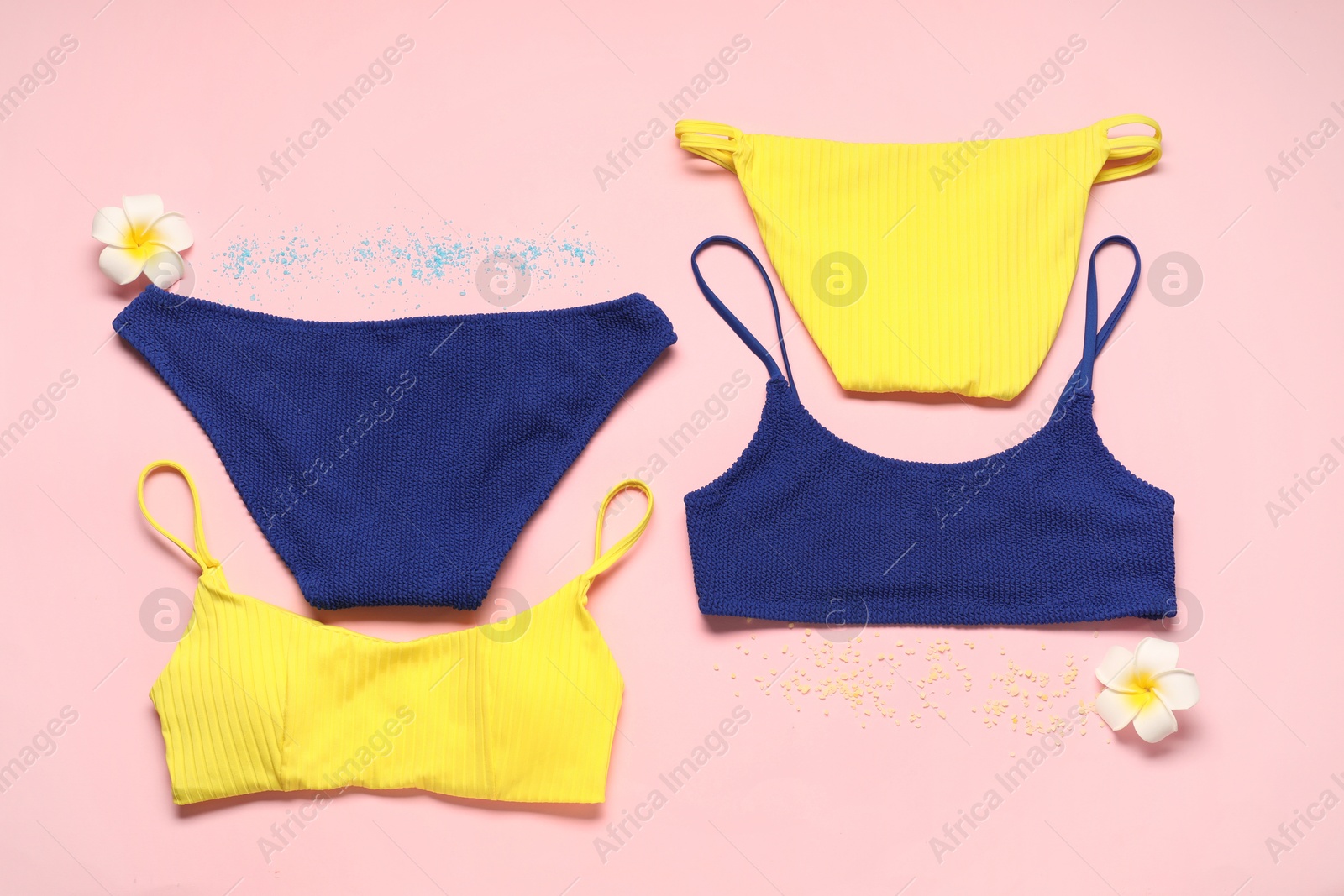 Photo of Flat lay composition with beautiful swimsuits on pink background