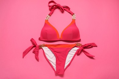 Beautiful swimsuit on pink background, top view