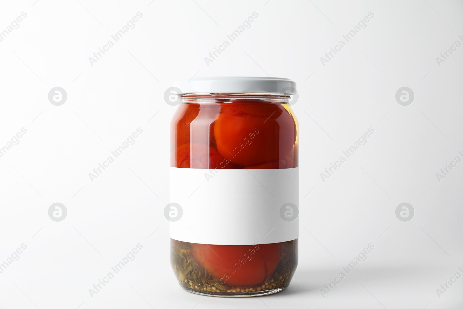 Photo of Tasty pickled tomatoes in jar on light background