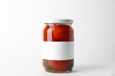 Tasty pickled tomatoes in jar on light background