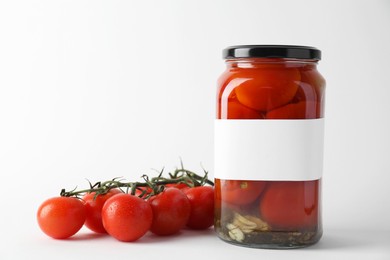 Photo of Tasty pickled tomatoes in jar and vegetables on light background, closeup