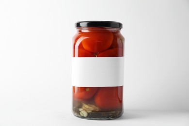 Tasty pickled tomatoes in jar on light background