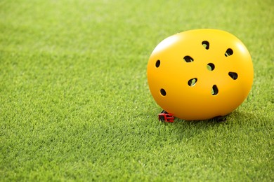 Photo of Yellow protective helmet on green grass, space for text