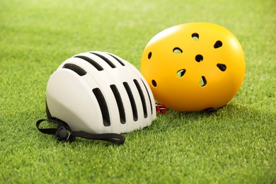 White and yellow protective helmets on green grass