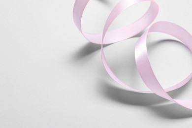 One beautiful pink ribbon on white background, space for text