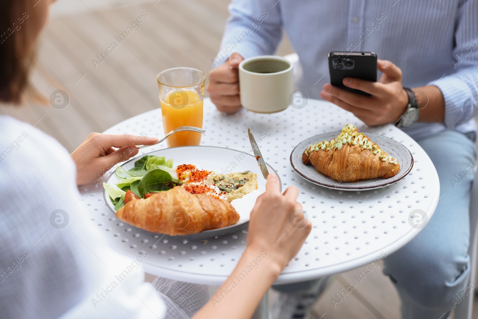 Photo of Couple having tasty breakfast in outdoor cafe, closeup