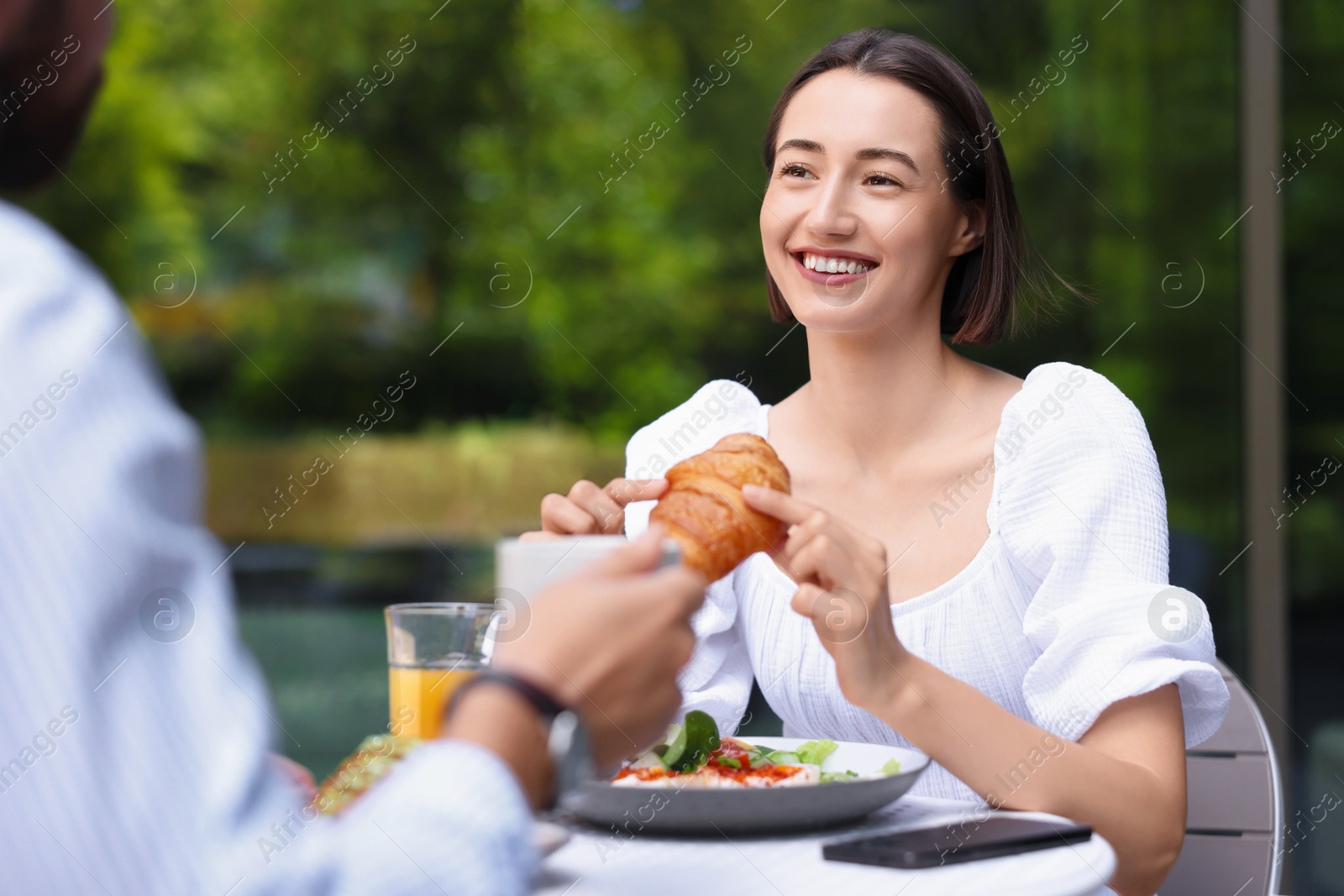 Photo of Happy couple having breakfast in outdoor cafe