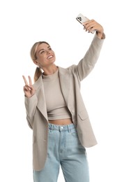 Beautiful woman in stylish jacket taking selfie on white background