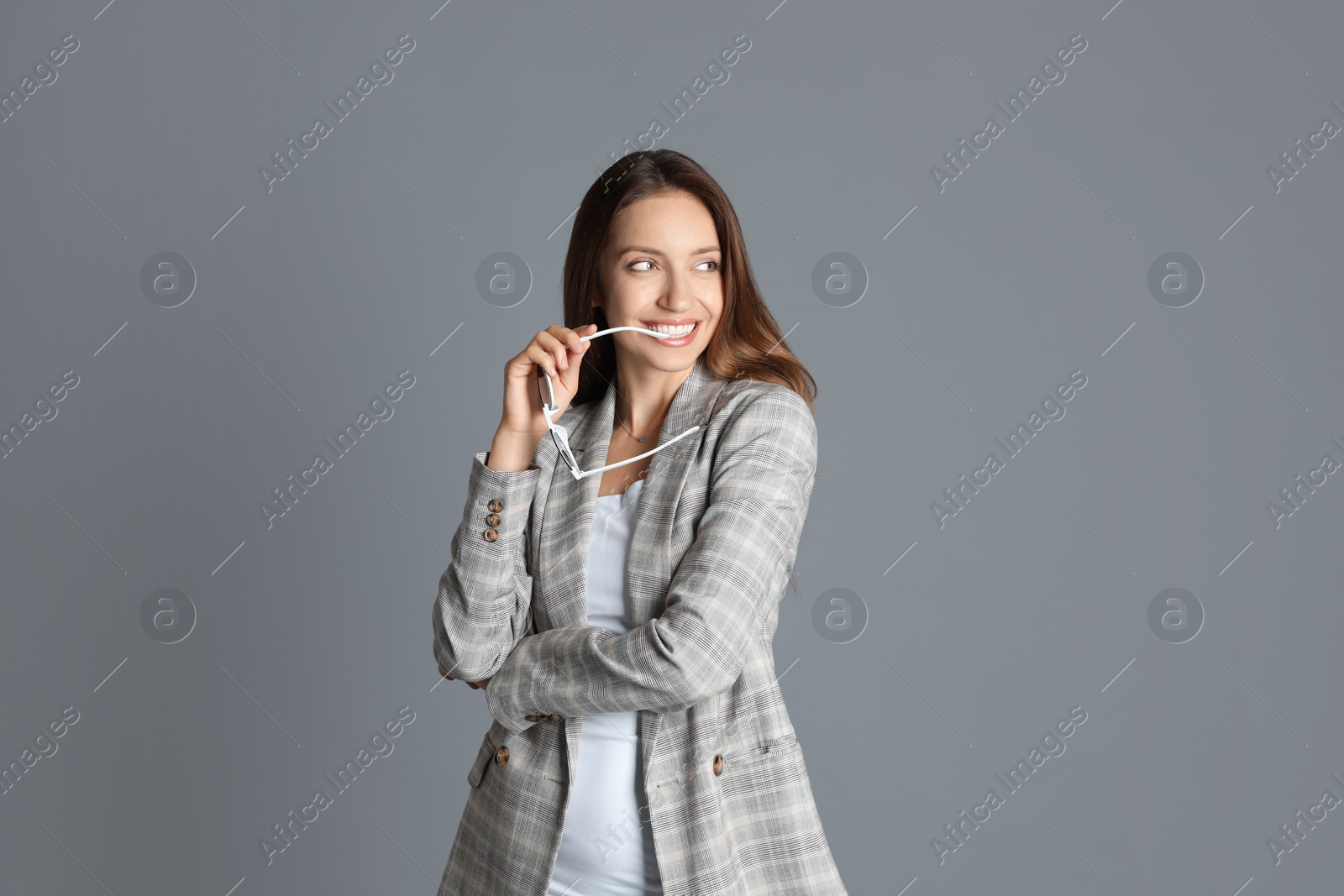 Photo of Beautiful woman with stylish jacket and sunglasses on grey background