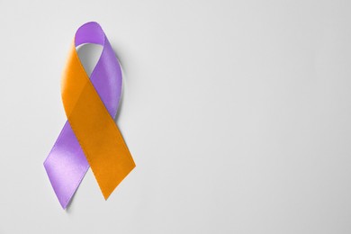 Image of World Psoriasis Day. Orange and orchid awareness ribbon as symbol of support on white background, top view. Space for text