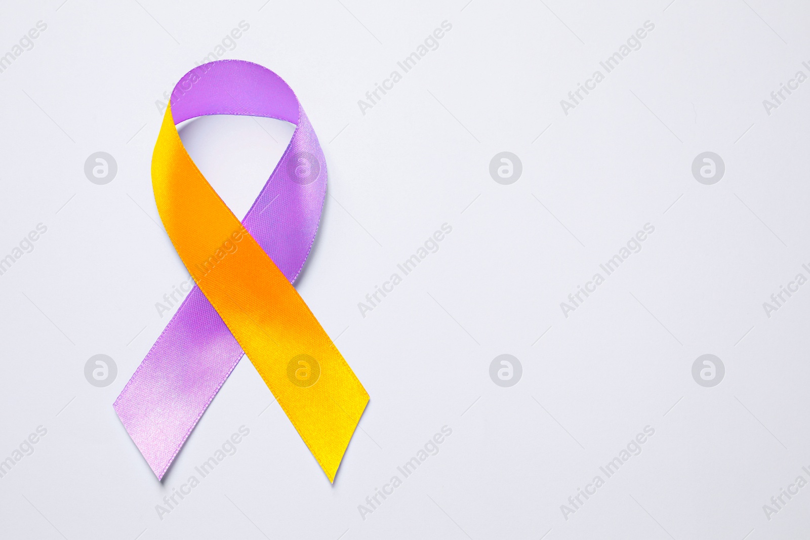 Image of World Psoriasis Day. Orange and orchid awareness ribbon as symbol of support on white background, top view. Space for text