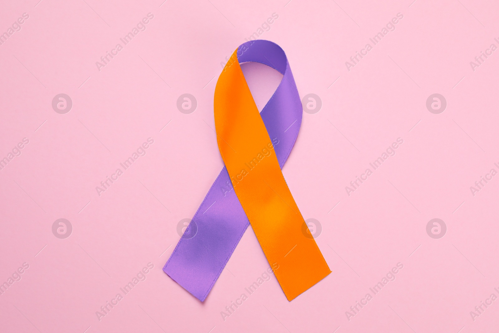 Image of World Psoriasis Day. Orange and orchid awareness ribbon as symbol of support on pink background, top view