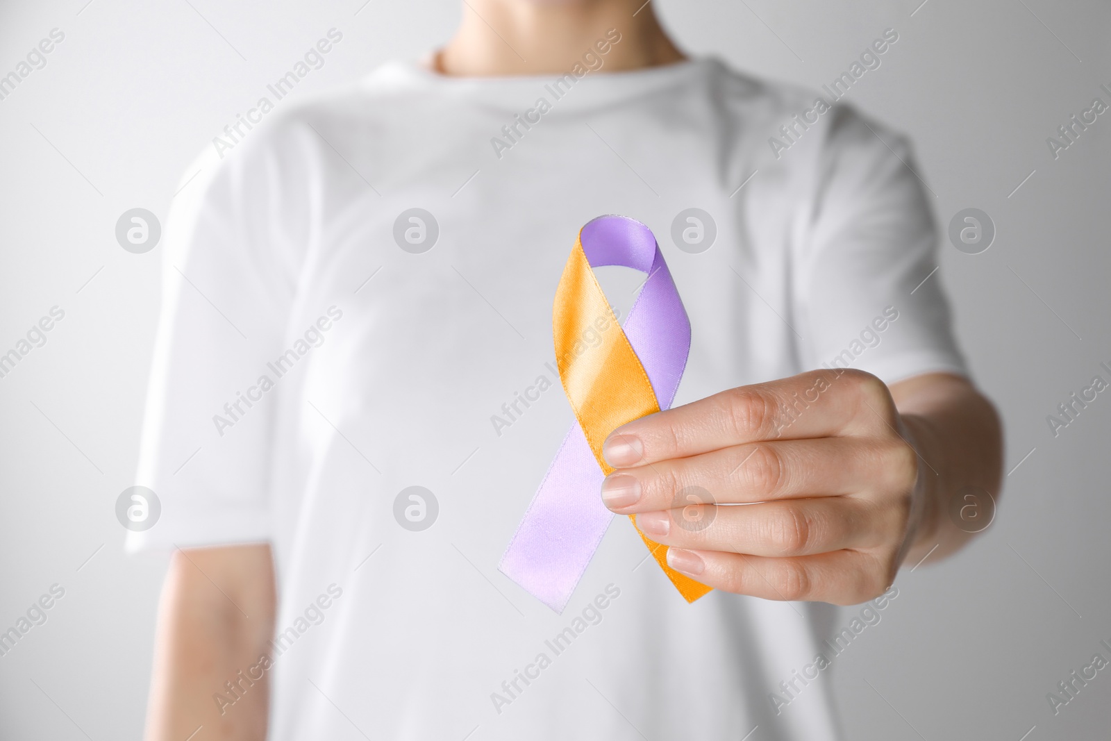 Image of World Psoriasis Day. Woman with orange and orchid ribbon as symbol of support on white background, closeup