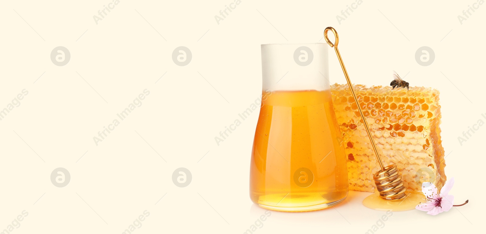 Image of Organic honey in glass jar, wooden dipper and honeycomb on light background. Banner design with space for text