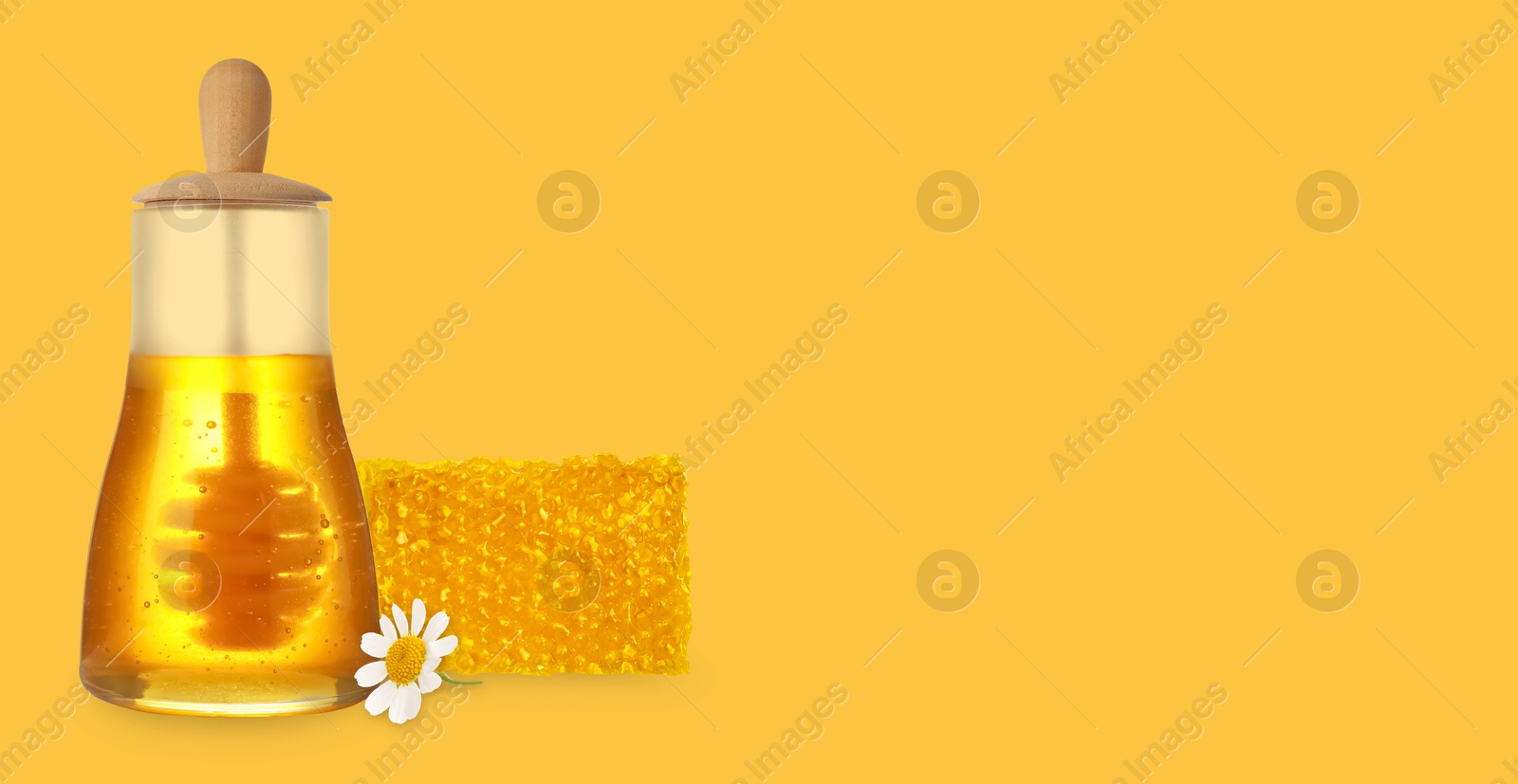 Image of Organic honey in glass jar and honeycomb on golden background. Banner design with space for text