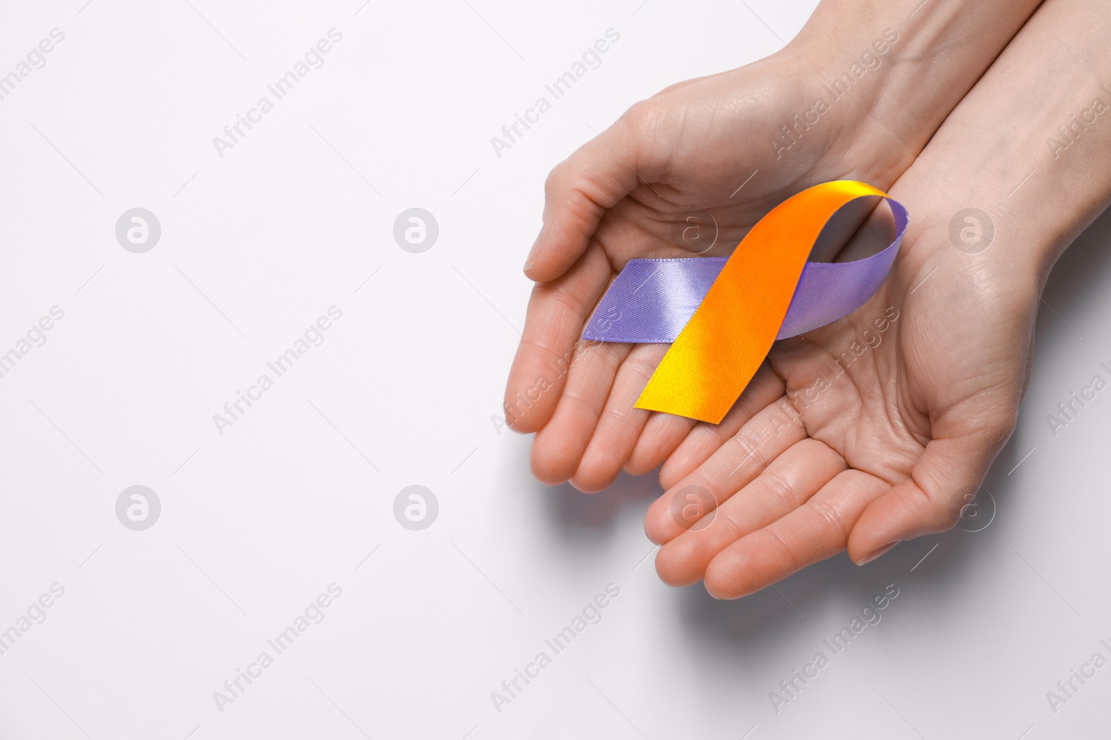 Image of World Psoriasis Day. Woman with orange and orchid ribbon as symbol of support on white background, top view. Space for text