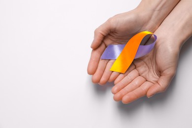 Image of World Psoriasis Day. Woman with orange and orchid ribbon as symbol of support on white background, top view. Space for text