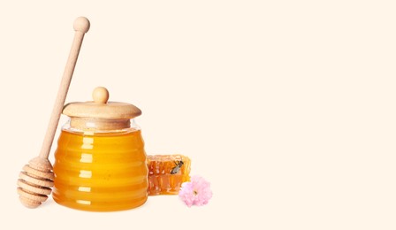 Image of Organic honey in glass jar, wooden dipper and honeycomb on light background. Banner design with space for text