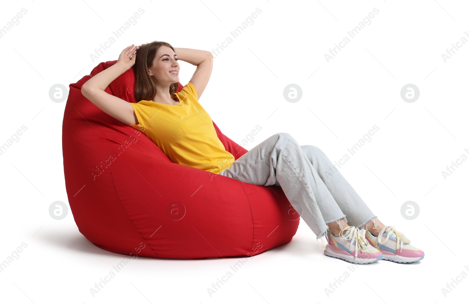 Photo of Smiling woman sitting on red bean bag chair against white background