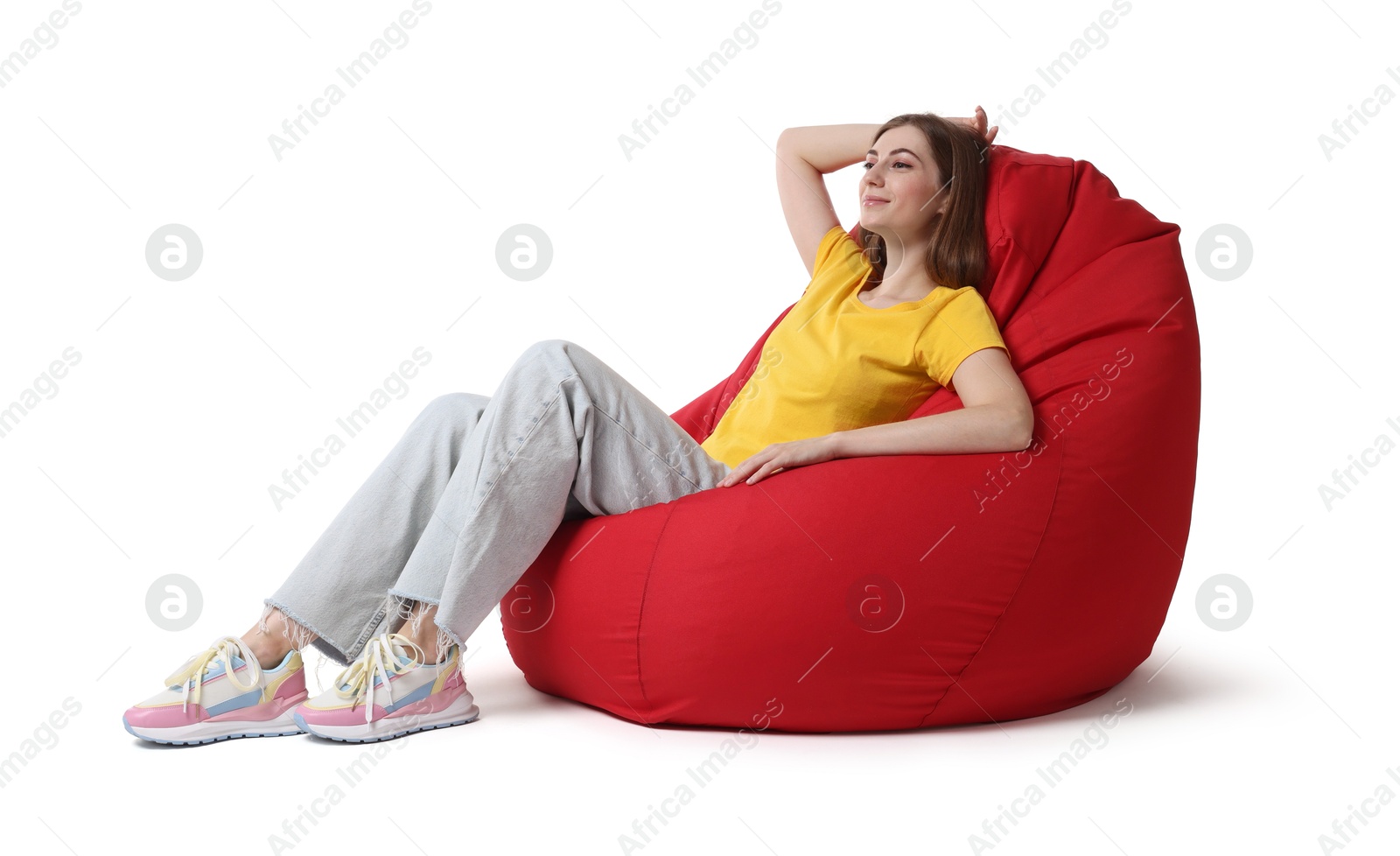 Photo of Beautiful young woman sitting on red bean bag chair against white background