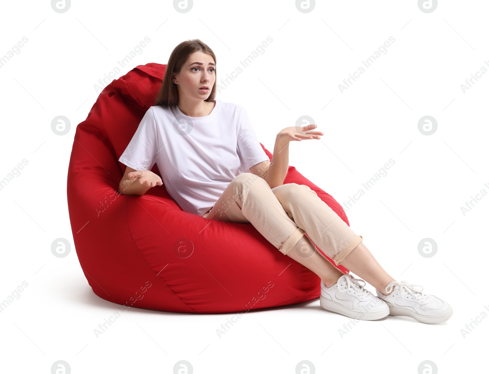 Photo of Emotional woman sitting on red bean bag chair against white background